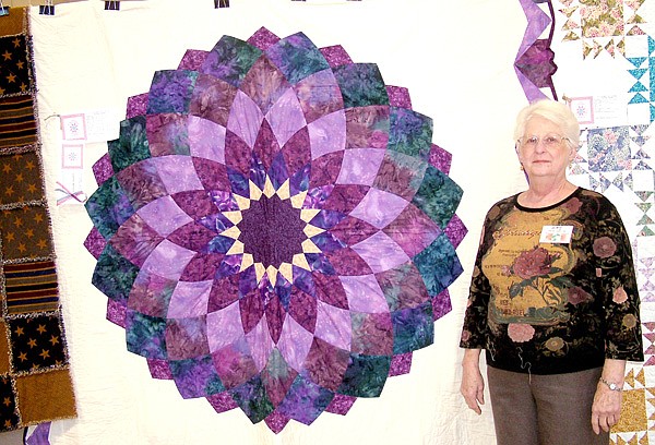 Amy McInturff stands beside her quilt — Dahlia — which won the grand prize for Best in Show at the Pea Ridge First Baptist Church Quilter’s annual quilt show Saturday.