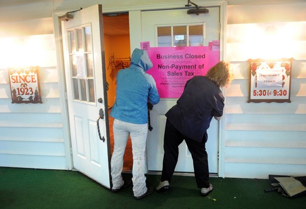 Officials from the Arkansas Department of Finance and Administration post a sign on the front doors of Mary Maestri’s in Tontitown on Friday after closing the popular Italian restaurant because of failure to pay at least $21,012 in sales taxes.