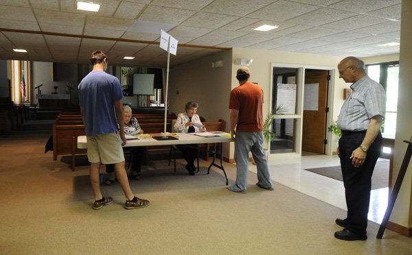 Poll supervisor Roger Schoolcraft, right, oversees the St. John's Lutheran Church in Fayetteville on Tuesday. The polling place had around 150 voters by lunch time.