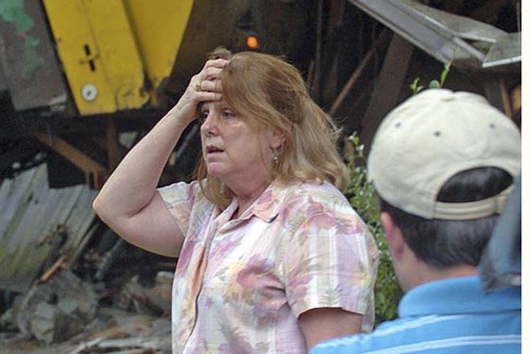 Rebecca Hochradel reacts Tuesday after her home at 8301 Alvin Lane in Little Rock was struck by a Waste Management truck rolling backward down a hill. The cause of the accident had not been determined. No one was home at the time, and there were no injuries. 