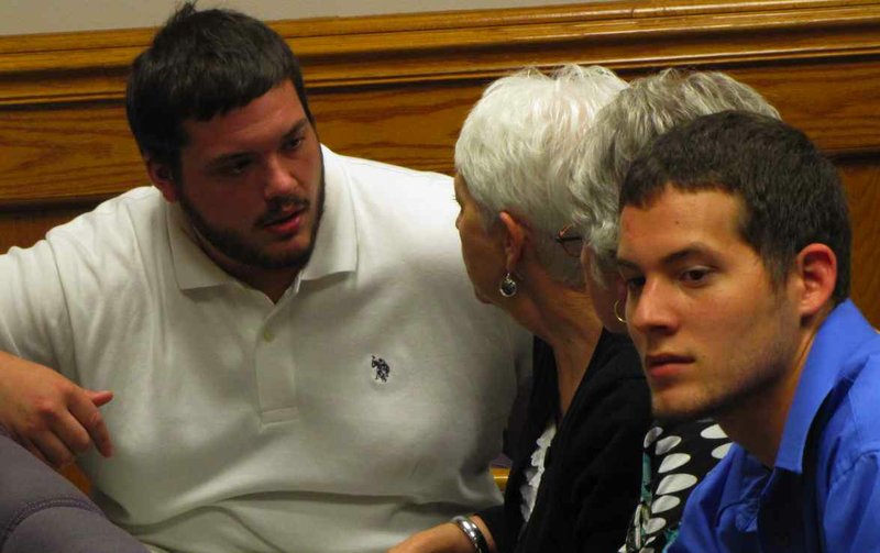 Lane New, left, talks with friends and family while waiting for a judge to decide if his mother was guilty of harassing him on Facebook.