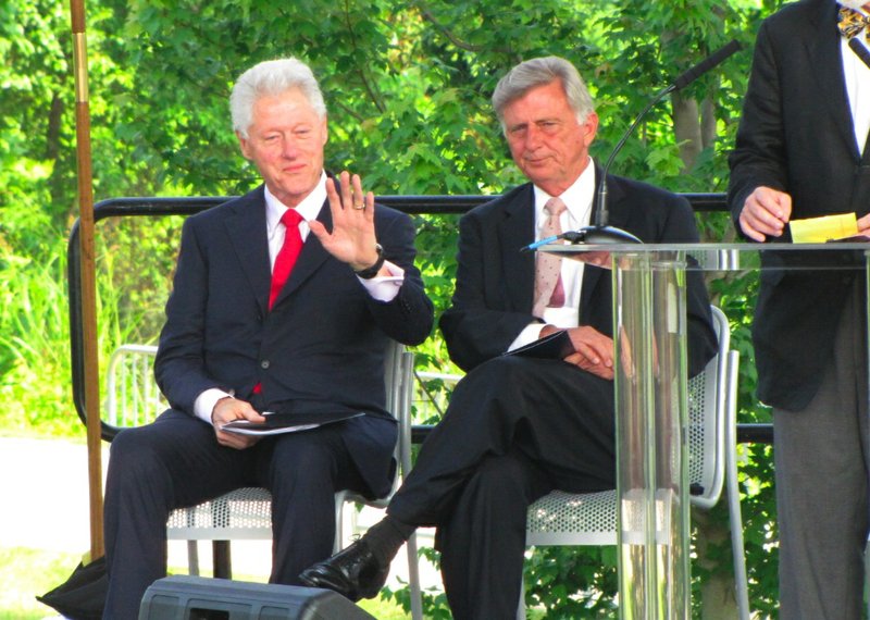 Former President Bill Clinton waves to the crowd while sitting with Gov. Mike Beebe during a groundbreaking for the Clinton Park Bridge renovation.