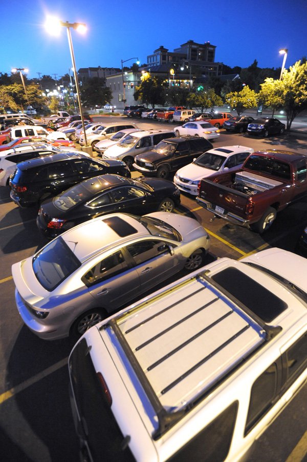 Automobiles fill the parking lot west of the Walton Arts Center on Thursday on West Dickson Street in Fayetteville. The City Council is considering ordinances that would transition this lot and others around the Walton Arts Center to paid parking. The lot at West Avenue and Dickson Street would be available on a pay-as-you-stay basis as well as part of a Walton Arts Center parking reservation program.