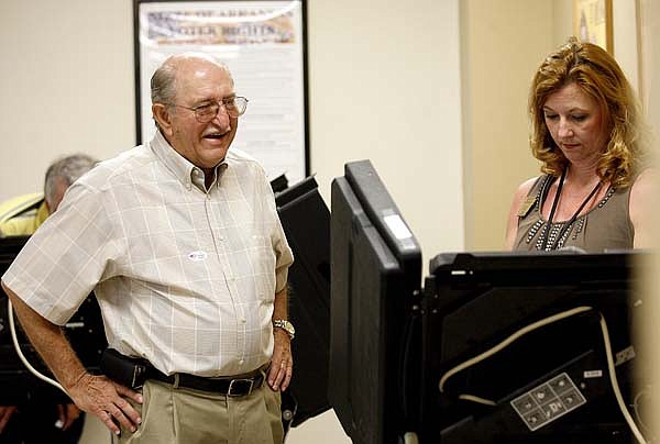  
Duane Neal of Bentonville (left) waits while election official Betsy Harrell of Pea Ridge starts the electronic ballot for him on Tuesday, June 1, 2010, inside the Benton County Administration Building in Bentonville. Early voting resumed for run-off elections on Tuesday.