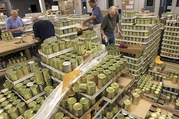 Lloyd Koby (from left), Bob Huebscman, Allen Holmes, Paul Langston and other volunteers from Christ of the Hills United Methodist Church in Hot Springs Village sort and label more than 250 types of canned vegetables Thursday at the Arkansas Rice Depot.