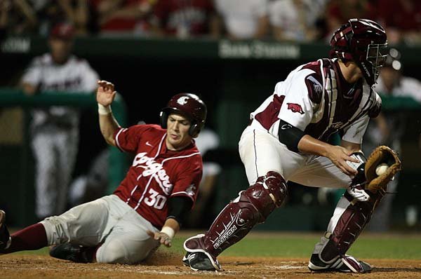 Washington State’s Jay Ponciano slides into home as Arkansas catcher James McCann gets the late throw from the outfield during Sunday’s game at Baum Stadium in Fayetteville. Arkansas lost 10-7 and will face Washington State again today in the deciding game.