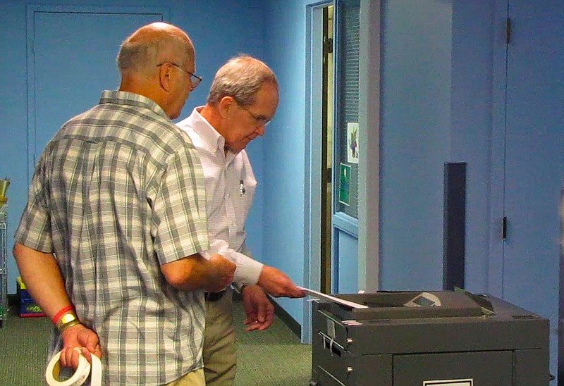 Poll worker Ernest Stander helps retired North Little Rock resident Lonnie Gibbons submit his ballot Tuesday morning at Central Baptist Church.