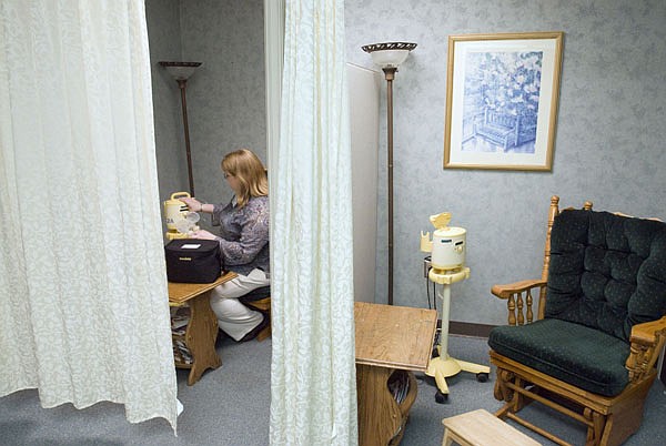 New mother Jennifer Maher, who works for Baptist Health Medical Center-Little Rock, attaches her personal equipment to a professional breast pump in the hospital’s special employee lounge for nursing mothers. 