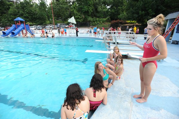 Lifeguard Raeanne Keller, right, gives a group of swimmers some last-minute instructions before the start of an attempt to set the world’s record for the largest swim lesson Friday at Wilson Park Pool in Fayetteville.