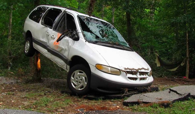 FILE PHOTO: A van swept away by floodwaters rests at an angle against a tree in 2010 at the Albert Pike campgrounds. The spraypaint on the passenger-side door signifies that it has been searched for victims.