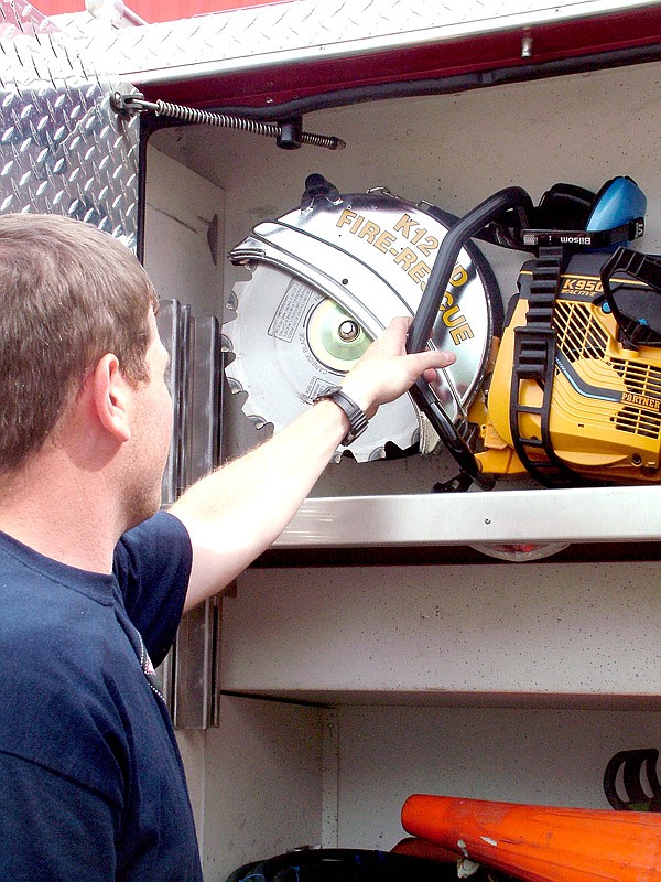 Capt. Brian Johnson shows the new circular saw which can cut either metal or wood.