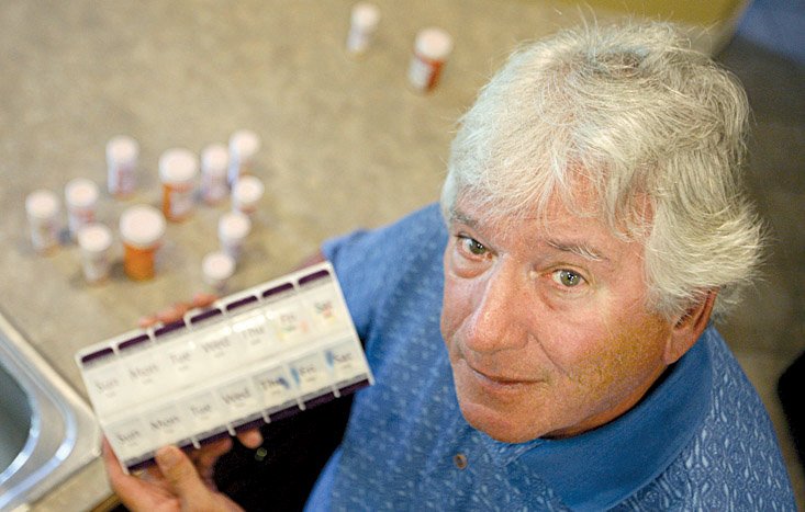 Jack Ballard at his Conway home with his assortment of prescription medicines. Ballard says he is now paying for more medicine out of pocket to avoid falling back into the doughnut hole.