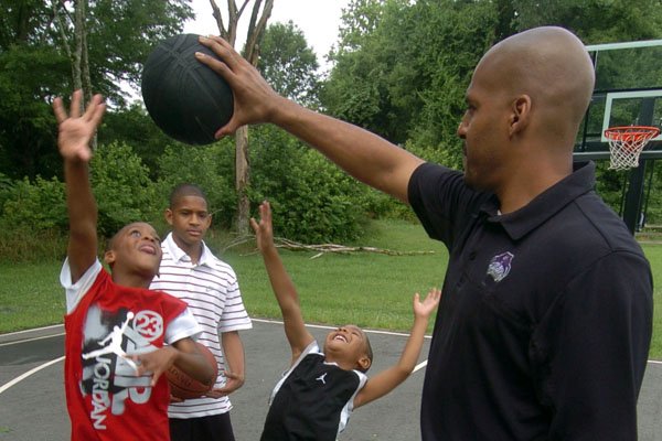 Corliss Williamson with sons Creed, Chasen and C.J. on the basketball court behind his house.
