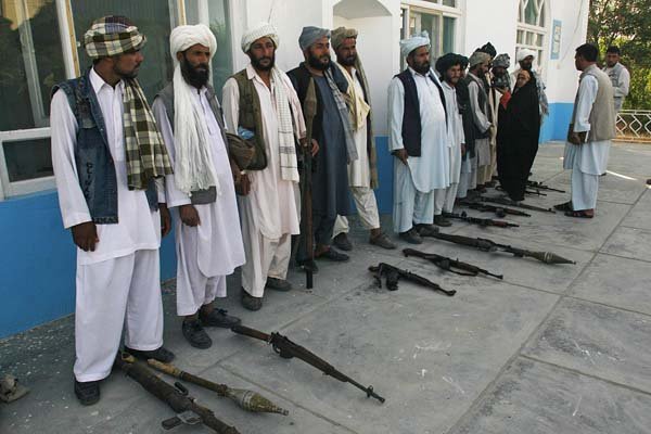 Former Taliban fighters surrender their weapons Saturday to Afghan authorities in Herat.