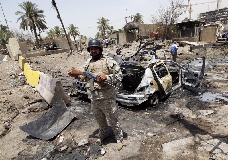 An Iraqi soldier stands guard at the site of a car-bomb attack in Baghdad on Sunday.