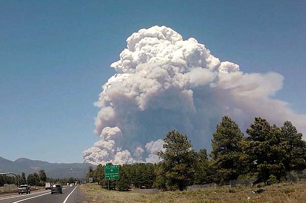 A wildfire burns at Shultz Pass between the San Francisco Peaks and Mount Elden near Flagstaff, Ariz., on Sunday.
