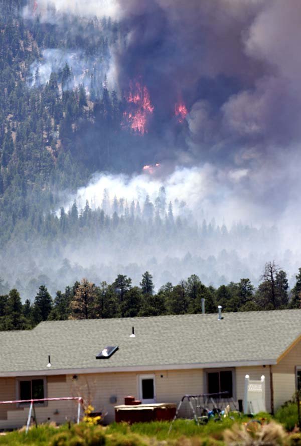 The Schultz fire burns behind homes Monday in Flagstaff, Ariz.