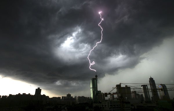 Lightning strikes the top of a building in Foshan in south China's Guangdong province, Monday. On Tuesday, President Hu Jintao and Premier Wen Jiabao have called for stepped-up rescue efforts after torrential rains brought down a dike in southern China, forcing 68,000 people to flee their homes.
