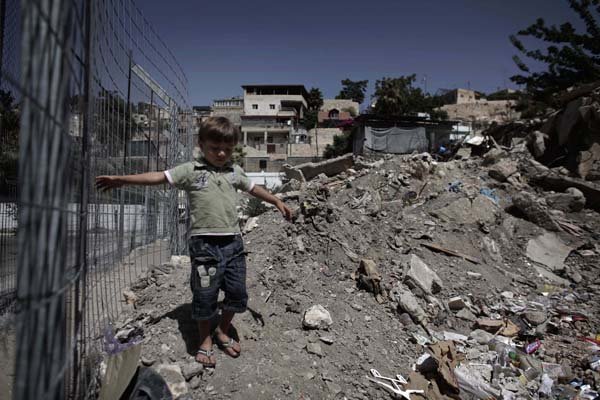 A Palestinian child walks over rubble in the east Jerusalem neighborhood of Silwan on Monday.