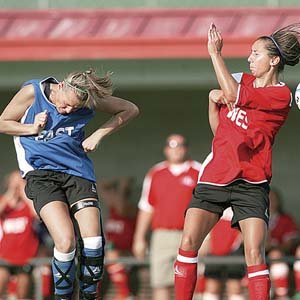 The East’s Jessica Wisenor (left) puts a header past the West’s Sarah Correll during the All-Star soccer game Tuesday at Razorback Field in Fayetteville.