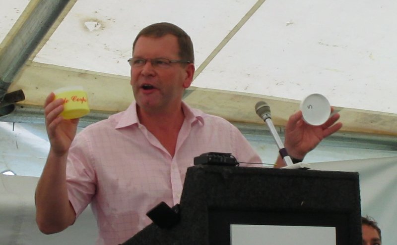 Malcolm Harrison, group director of Rexam Plastic Packaging, holds up two of the plastic products made at the Hot Springs plant during an event announcing 150 new jobs there.