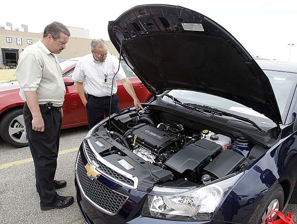 Rob Greenaway (left) and Bob Ratu inspect the engine on a test model of the new Chevrolet Cruze last week at the Lordstown Assembly Plant in Lordstown, Ohio.