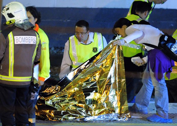 Police and rescue workers inspect a victim at the Castelldefels Playa station where a high-speed train passing through the station struck a group of people crossing the tracks, in Castelldefels, Spain, Thursday.