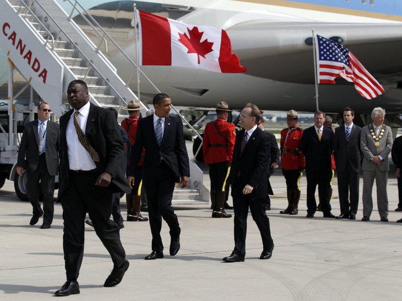 President Barack Obama walks with Canada’s Chief of Protocol Robert William Peck after arriving Friday in Toronto.