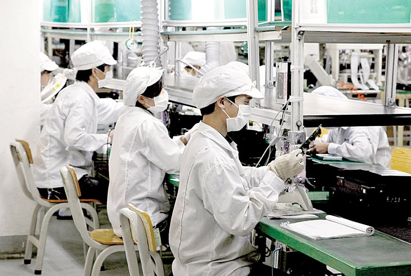 Employees work on an assembly line last month at a Foxconn Technology Group plant in Shenzhen, China.