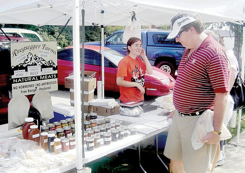 A shopper looks over prepared foods displayed Saturday at a farmer’s market near downtown Milwaukee. Wisconsin lawmakers enacted the so-called Pickle Bill in February that allows vendors to sell some canned foods without a license.