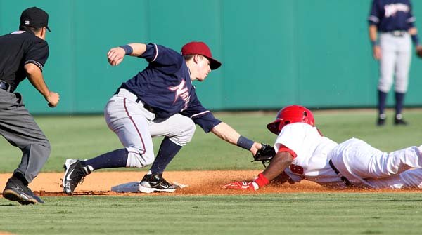 Northwest Arkansas’ Chris McConnell (left) tags out Arkansas’ Jeremy Moore during the first inning of Sunday’s game at Dickey-Stephens Park in North Little Rock.