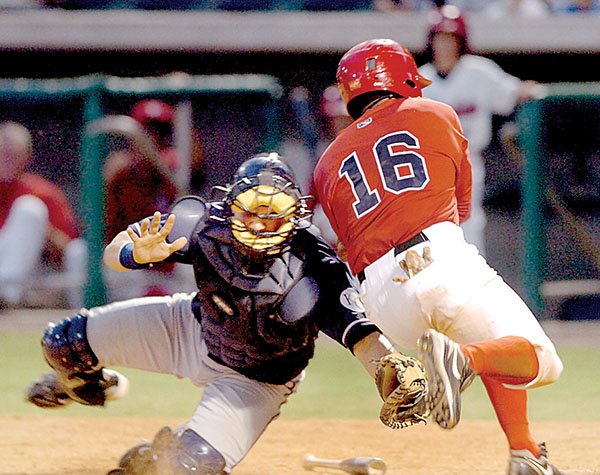 Arkansas Travelers base runner Efren Navarro (16) is tagged out by Northwest Arkansas’ Manuel Pina to complete a double play during the fourth inning Monday at Dickey-Stephens Park in North Little Rock.