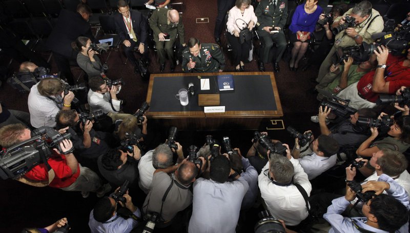 Photographers gather around Gen. David Petraeus as he gives a thumbs-up, on Capitol Hill in Washington on Tuesday, June 29, 2010, prior to his testifying before the Senate Armed Services Committee. 