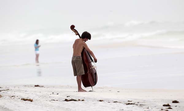 Harrison Wallace of Montgomery, Ala., plays his upright bass on the beach just after dawn in Destin, Fla., on Monday.