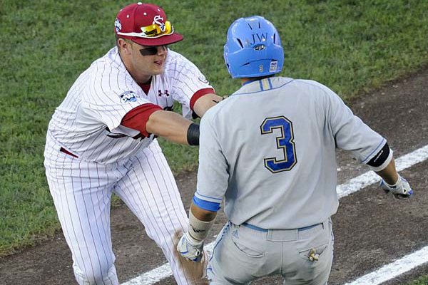 South Carolina first baseman Christian Walker (left) tags out UCLA’s Steve Rodriguez during the fifth inning Tuesday at the College World Series. The Gamecocks won 2-1 in 11 innings to claim their first national championship.