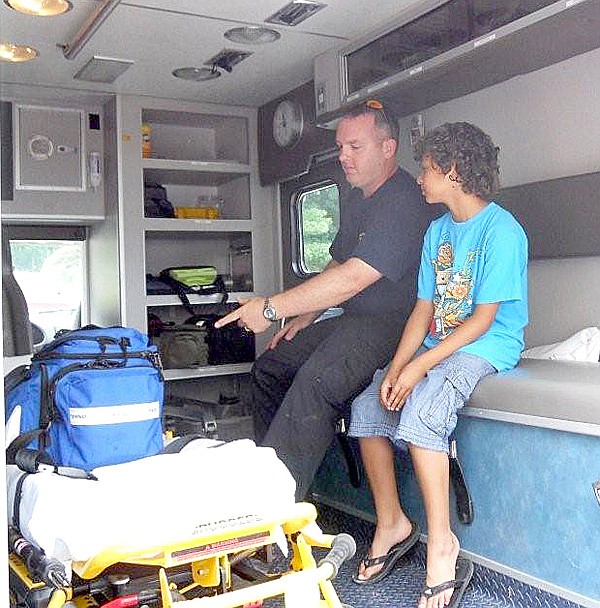 NEBCO emergency medical technician Jamie Baggett showed off the workings inside a NEBCO ambulance to Danny Berkvens during the open house Saturday, June 26, at the new Station 2 on Posy Mountain Road in Garfield. Danny is the son of Clarice and Pieter Berkvens, new residents of the Lost Bridge Village community, which is served by NEBCO Station 2.