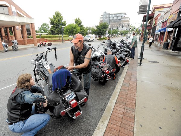 Friends Ron Hutchins and Sandy Vick, both of Mountain Home, load their belongings Saturday into Hutchins’ motorcycle parked along West Dickson Street in Fayetteville before taking part in the third and final day of the Bikes, Babes & Bling motorcycle rally in Fayetteville. 