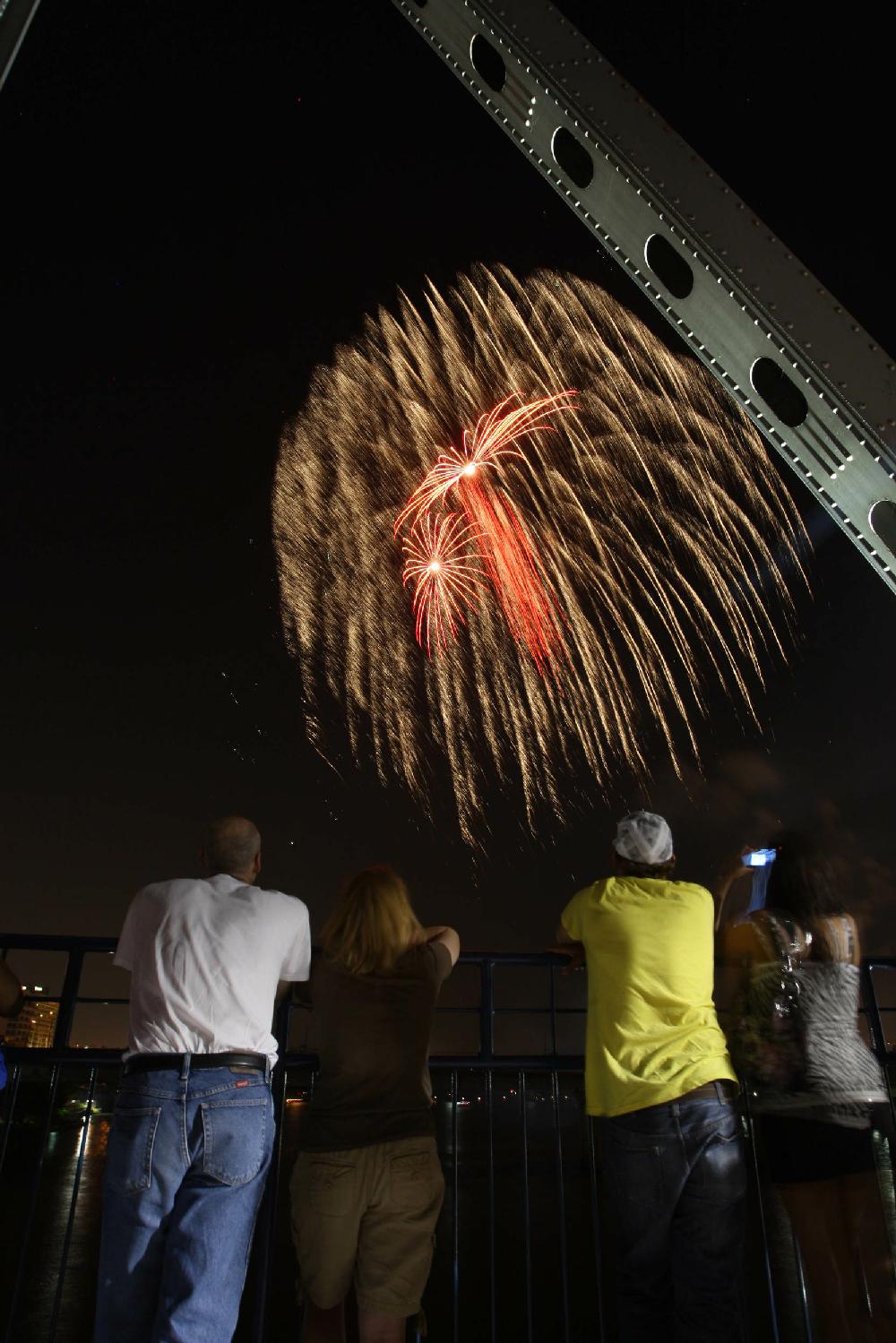 7410Arkansas Democrat-GazetteSTEPHEN B. THORNTONSpectators watch the Pops on the River fireworks display from the Junction Bridge over the Arkansas River Sunday night.