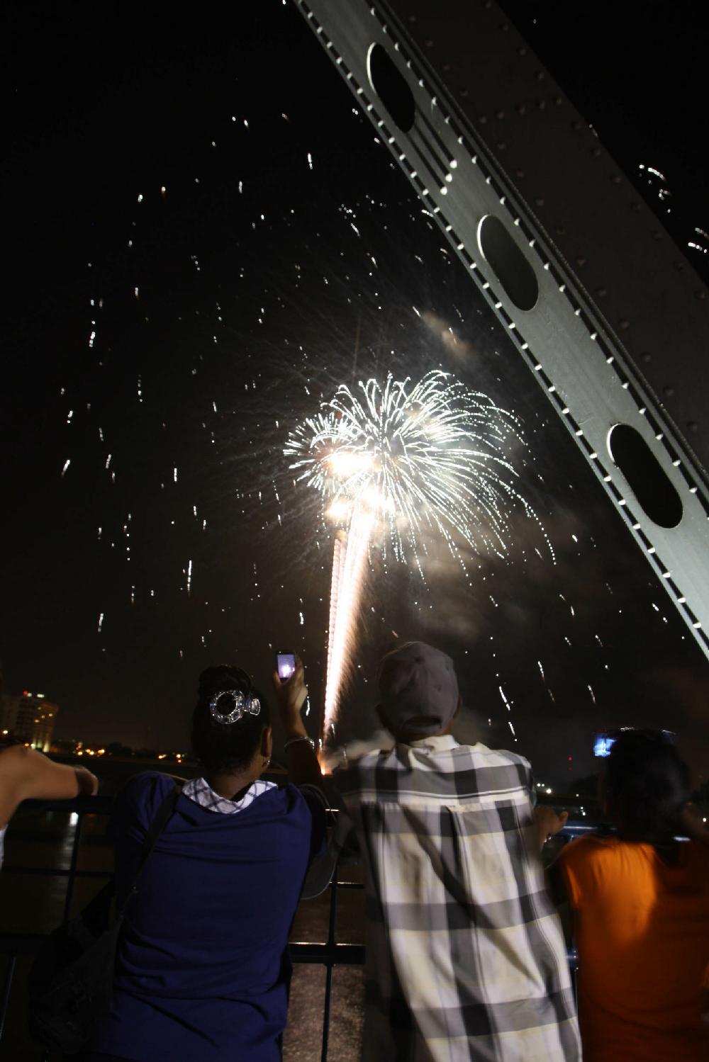 7410Arkansas Democrat-GazetteSTEPHEN B. THORNTONSpectators watch the Pops on the River fireworks display from the Junction Bridge over the Arkansas River Sunday night.