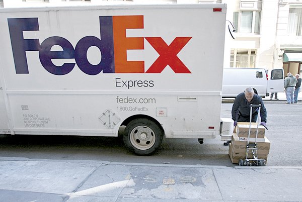  A FedEx Corp. employee unloads packages from a truck while making deliveries in New York, U.S., on Thursday, March 18, 2010. 