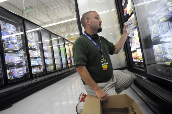 Walmart associate Chris Loucks stocks Great Value frozen food items May 4 at Walmart Neighborhood Market in Bentonville.