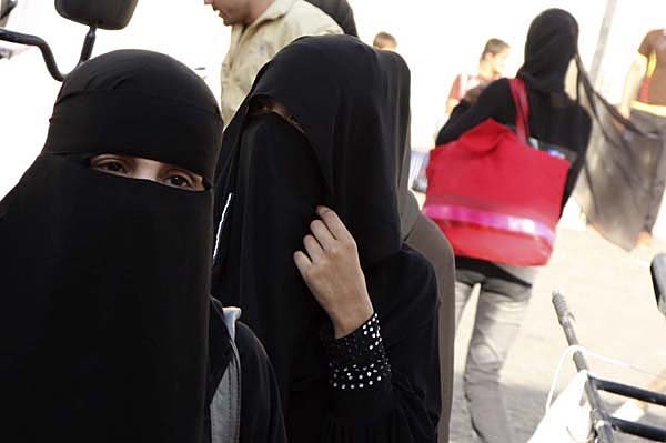 Women wear the niqab, a face-covering Islamic veil, as they shop in Souk Al-Hamediah, the oldest market in Damascus, Syria, on Monday. Syria has banned such veils from the country’s universities.