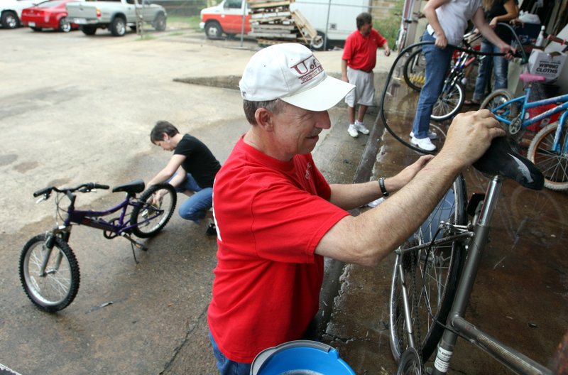 Jan Zanoff, left, and her husband Mike Zanoff scrub scrub bikes Saturday morning on the loading dock of the Little Rock warehouse which serves as the home base for the "Recycled Bikes For Kids" program.
