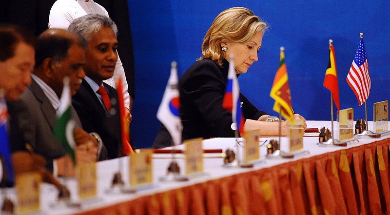 U.S. Secretary of State Hillary Rodham Clinton, right, signs the Treaty of Amity and Cooperation along with others at the end of the 17th ASEAN Regional Forum in Hanoi, Vietnam, on Friday, July 23, 2010. 