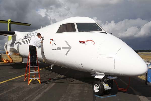 An exhibitor opens the door of a Bombardier Q400 aircraft on display Thursday at the Farnborough International Airshow in Farnborough, England.