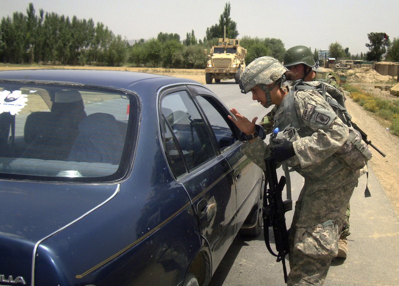 A U.S. soldier with the NATO-led International Security Assistance Force (ISAF) chats with a driver during a search for the two missing U.S. Navy personnel at a joint check post with Afghan soldiers in Pul-e-alam, Logar province of Afghanistan on Sunday, July 25, 2010. The Taliban have offered to exchange the body of a U.S. Navy sailor they said was killed in an ambush two days ago in exchange for insurgent prisoners, an Afghan official said Sunday. 