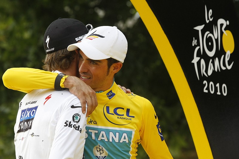 Three-time Tour de France winner Alberto Contador of Spain, right, hugs second-placed Andy Schleck of Luxembourg, wearing the best young rider's white jersey, on the podium after the 20th and last stage of the Tour de France cycling race over 102.5 kilometers (63.7 miles) with start in Longjumeau and finish in Paris, France, Sunday, July 25, 2010. 