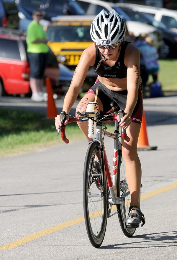 Maggie Pickhardt pedals her way to her third victory in women’s sprint division of the Shark Fest IV Triathlon at Horseshoe Bend Park on Sunday at Beaver Lake.