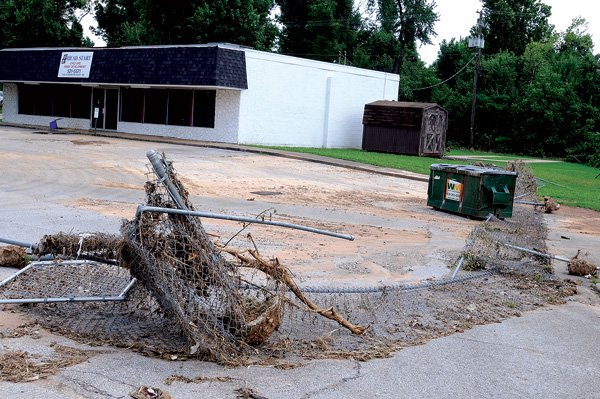 A fence that once bordered the Head Start building in Springdale lays in the parking lot July 14 after it was ripped up in a flood from a nearby creek.