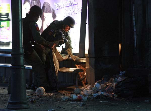 Thai bomb squad members examine the site of a blast near a bus stop in Bangkok on Sunday.